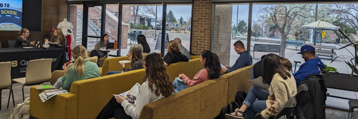 An image of students sitting in rows of couches for a presentation in the T. Rowe Price Career and Innovation Center.