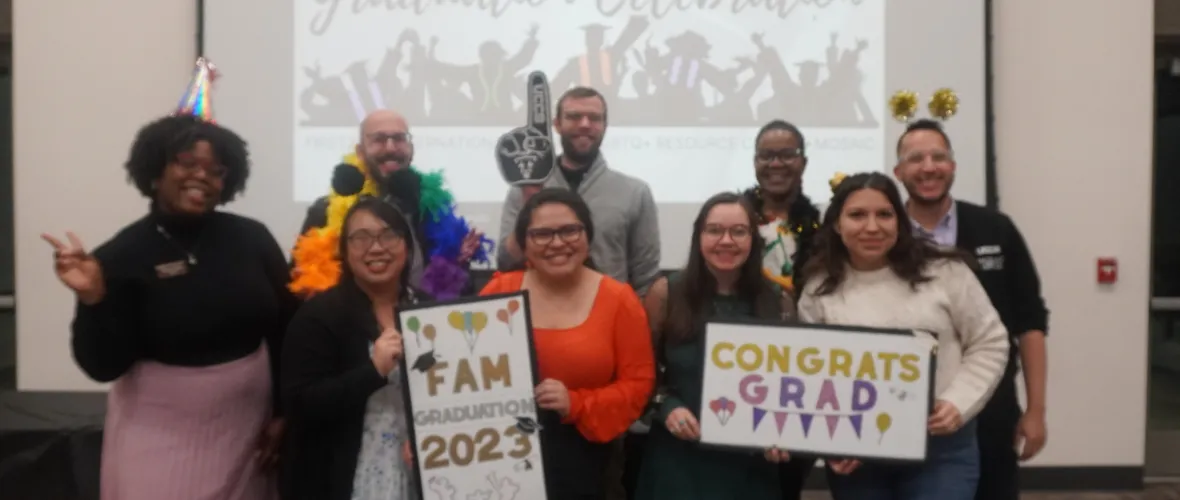 A photo of the staff who worked on FAM graduation holding props and smiling. From left to right, Whitley Hadley, Rame Hanna, Xuan Troung, Jon DeWitt, Ashley San Miguel, Karlye Enkler,  Nicole Simmons-Rochon, Sloan Gonzalez, and Rafael Norwood